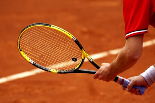 Mains tenant une raquette de tennis